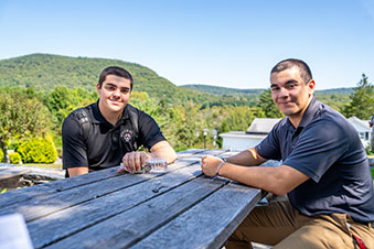 Two students sit outside together. Links to What to Give Two students sit outside together. Links to What to Give