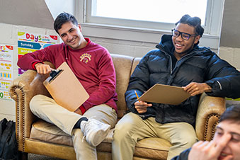 Students sit on a couch and laugh at something someone said during a class exercise. Links to Gifts of Life Insurance
